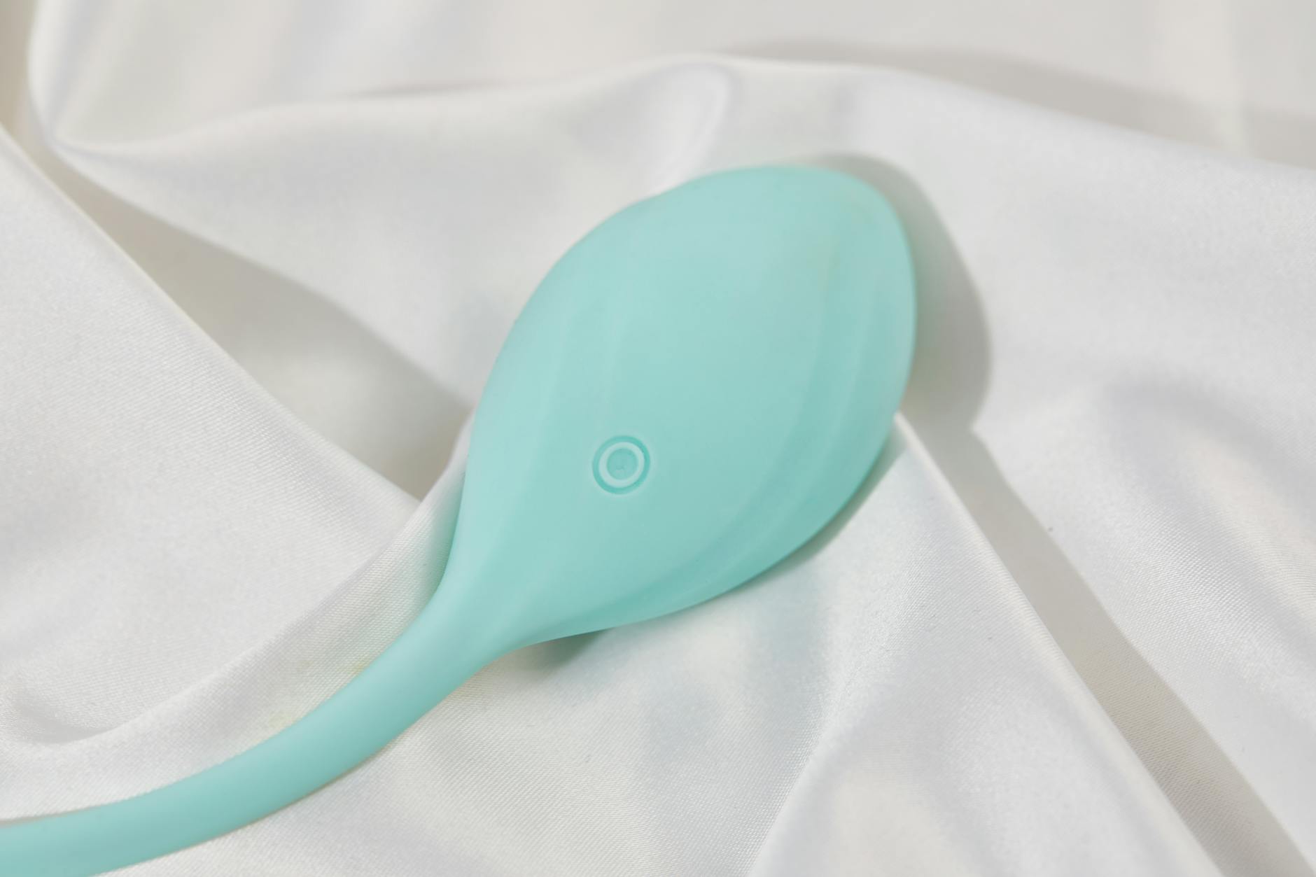 Vibrador rosa em fundo roxo com confete de corações e velas, representando intimidade e reconexão