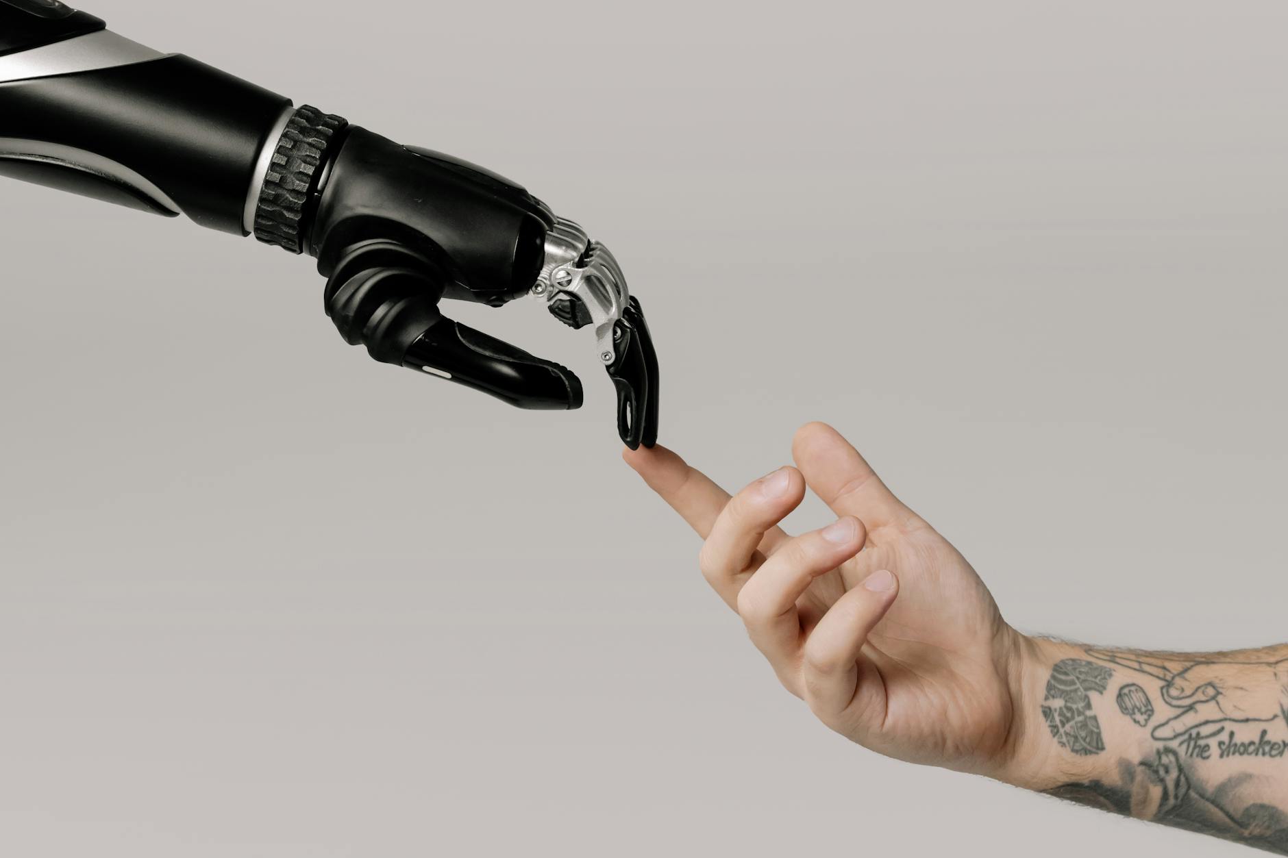 Mão humana e mão robótica se estendendo uma para a outra, simbolizando conexão além da tecnologia