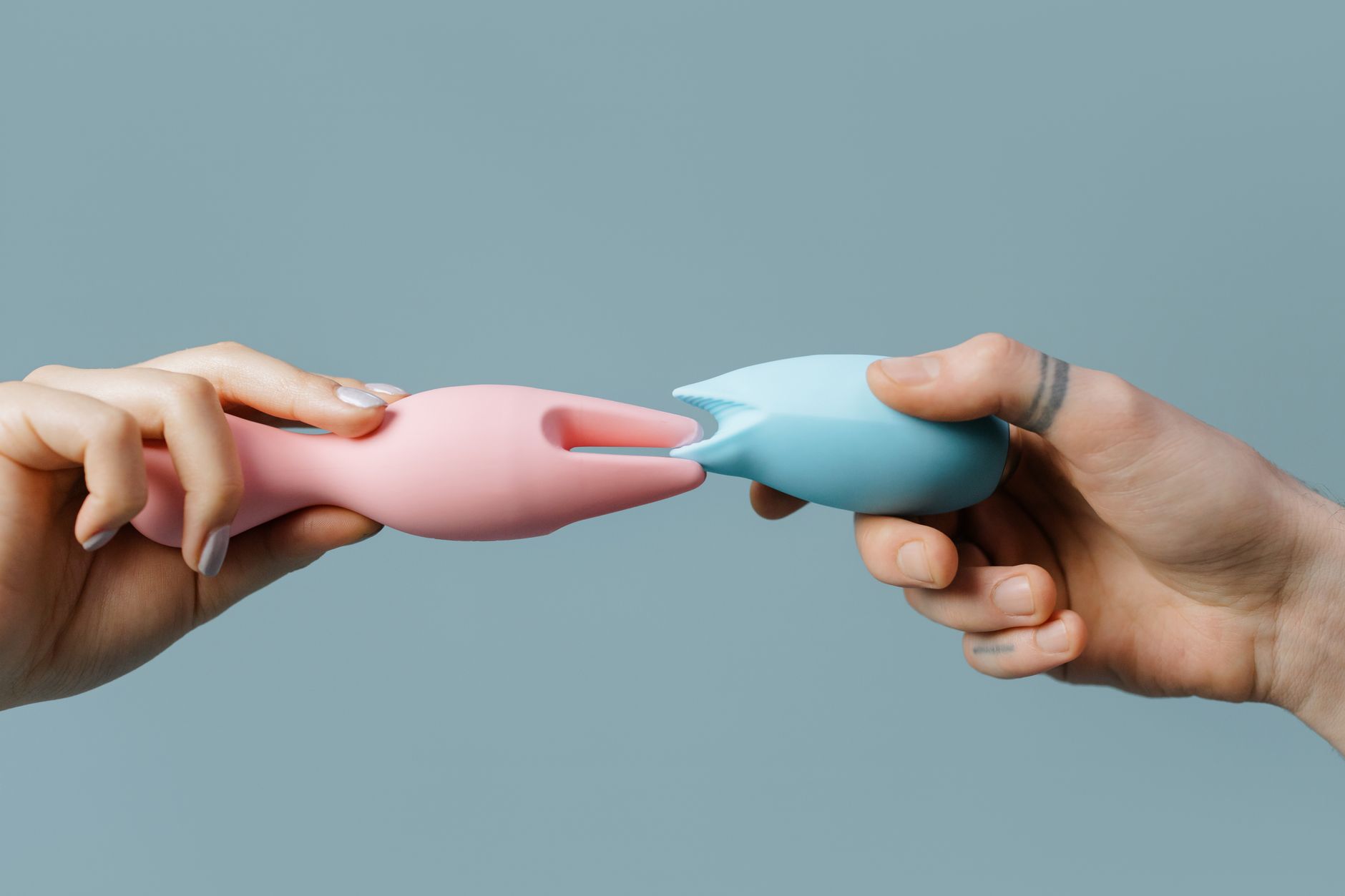 Mãos segurando brinquedos de silicone pastel