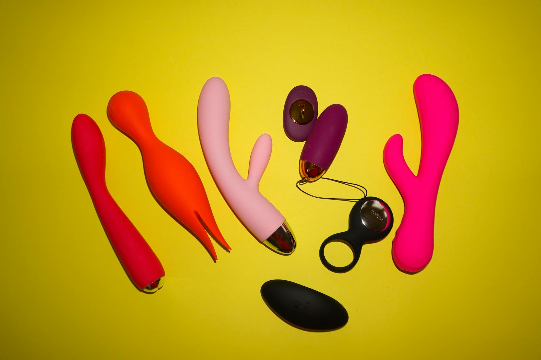 Mulher segurando vibrador clitoral azul e rosa, expressão pensativa
